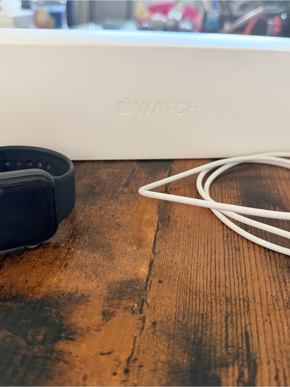 Apple Watch in Black with White Charging Cable